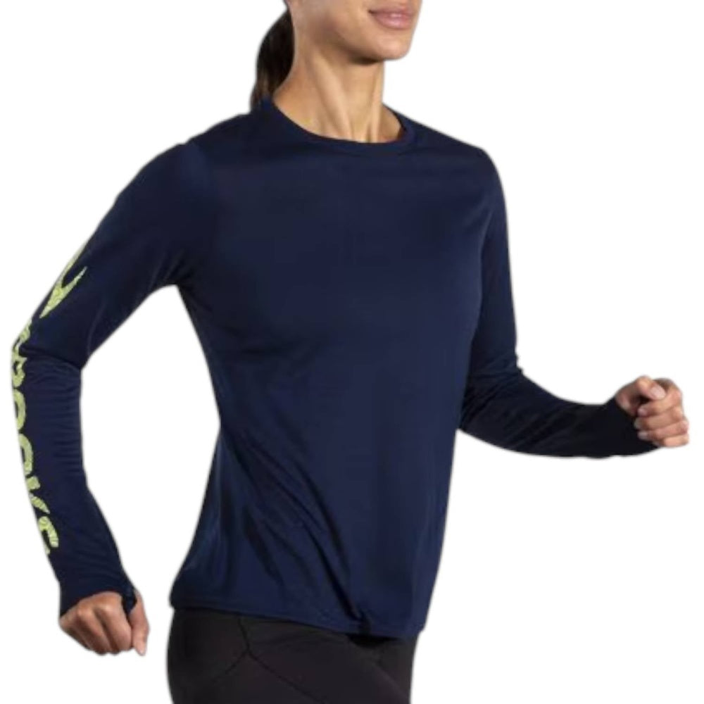Woman running in Brooks Distance Long Sleeve navy blue shirt with lime green logo