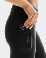 Side view of On Running black tights showing phone being placed into side pocket