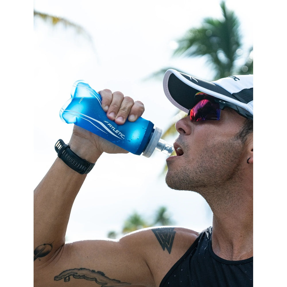 Athlete drinking from Fitletic Flow Max blue soft flask 350ml during outdoor run