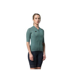 Woman wearing sage green Gobik Phantom cycling jersey with black shorts