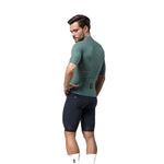 Male model wearing Gobik Phantom Jersey in sage green with navy cycling shorts