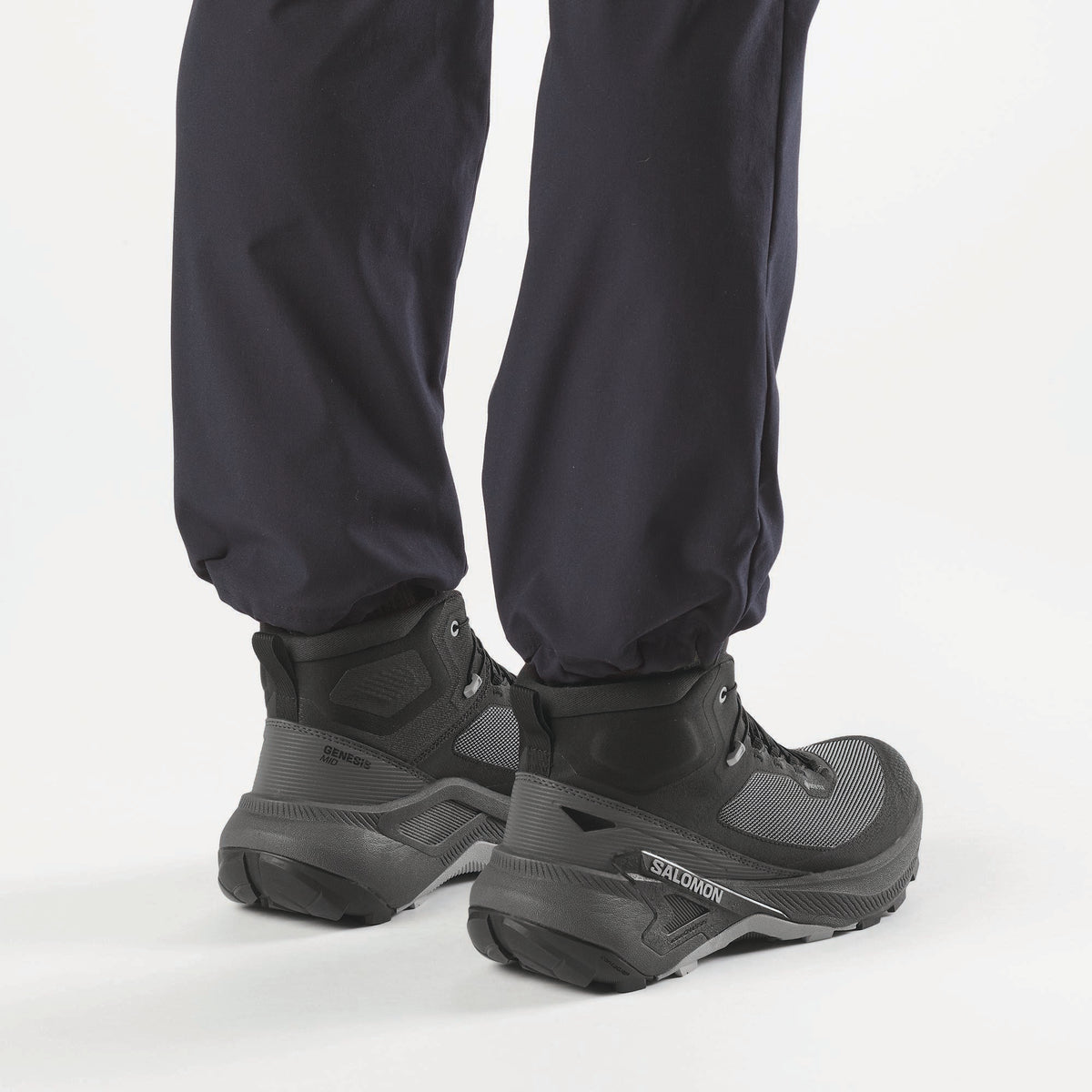 Salomon Genesis MID GTX boots worn on feet with navy pants, rear lifestyle view