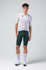 Male model wearing Gobik Limited Edition Attitude white cycling jersey with dark green bib shorts