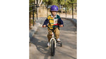 Young child riding a bicycle outdoors wearing the Thousand JR purple kids helmet