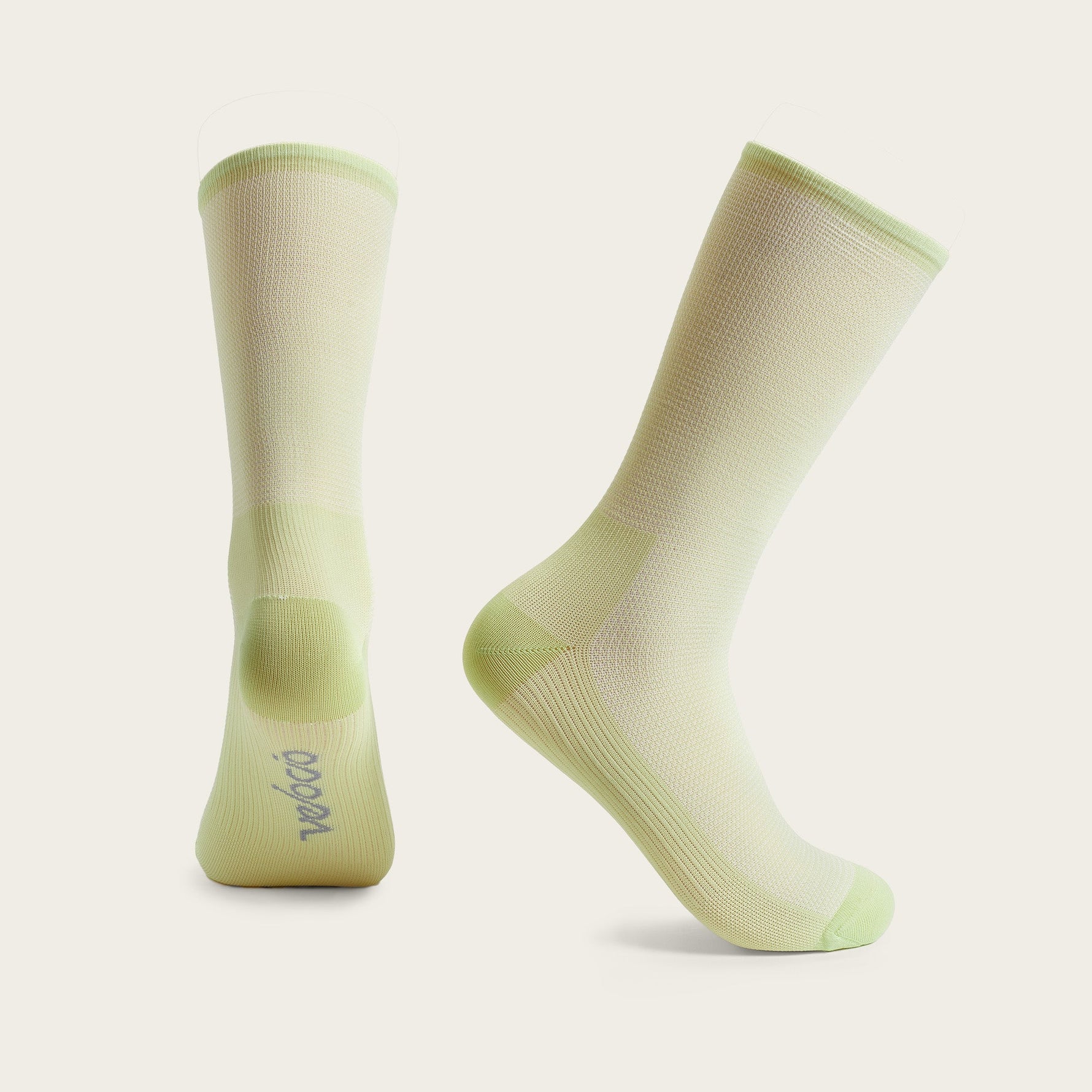 Pair of light green cycling socks with gradient pattern on neutral background